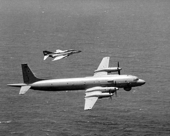 Ił-38 lecący nisko tuż nad powierzchnią wody w asyście samolotu US Navy Vought A-7E Corsair II. 
Zdjęcie: www.fas.org