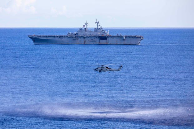 Śmigłowiec MH-60R Seahawk, z Marine Strike Squadron (HSM) 46, przygotowuje się do opuszczenia sonaru podczas szkolenia przeciw okrętom podwodnym (ASW). W tle desantowy okręt USS Wasp (LHD 1), 13 września 2020. / Zdjęcie: (Eric Shorter / US Navy)