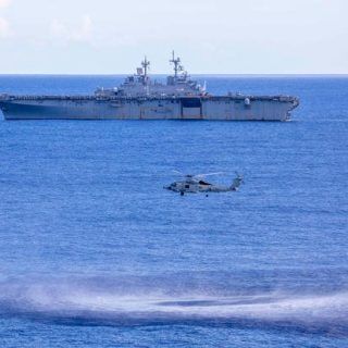 Śmigłowiec MH-60R Seahawk, z Marine Strike Squadron (HSM) 46, przygotowuje się do opuszczenia sonaru podczas szkolenia przeciw okrętom podwodnym (ASW). W tle desantowy okręt USS Wasp (LHD 1), 13 września 2020. / Zdjęcie: (Eric Shorter / US Navy)